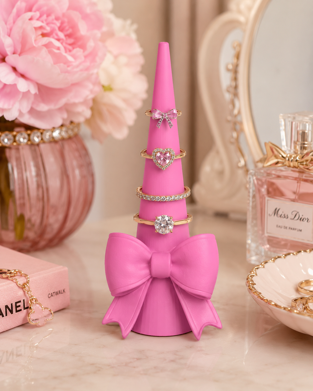 Pink coquette bow ring holder with rings displayed on vanity